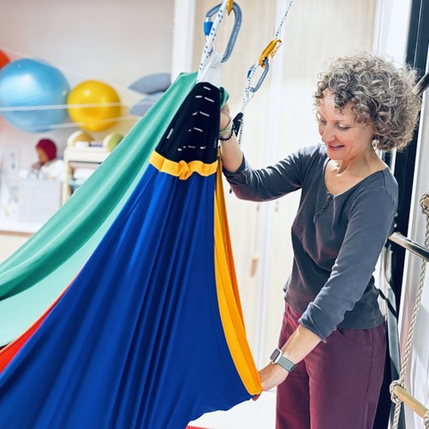Ergothérapeute installant une balançoire sensorielle